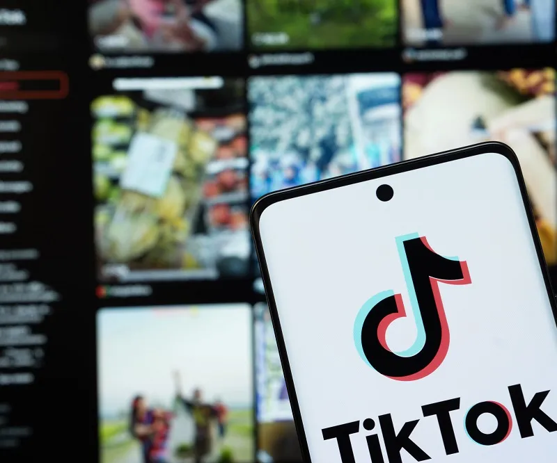 Tiktok app open on screen in front of an advertising platform on a computer