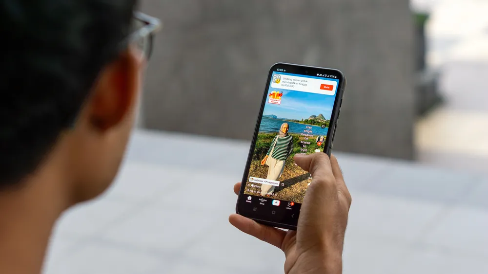 Chinese man looking at a phone delivering an ad on TikTok