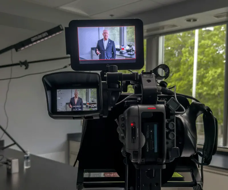 a man in front of a camera shooting a video marketing clip